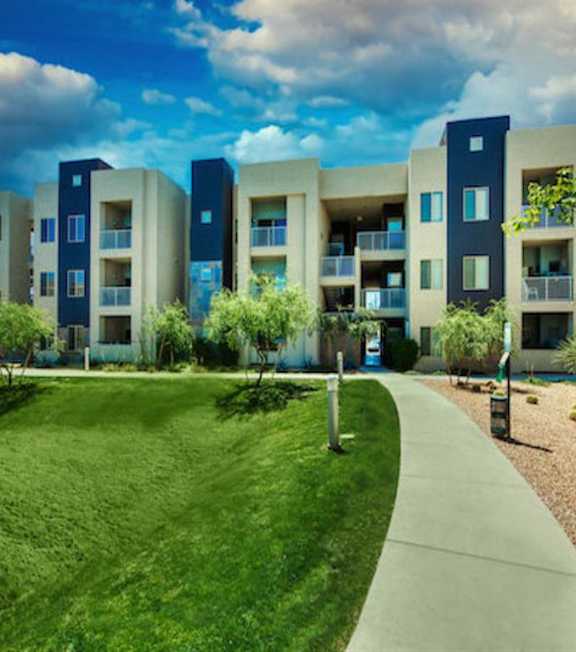 A modern apartment complex with a green lawn in front at Craft at Gilbert and Baseline Apartments, Arizona