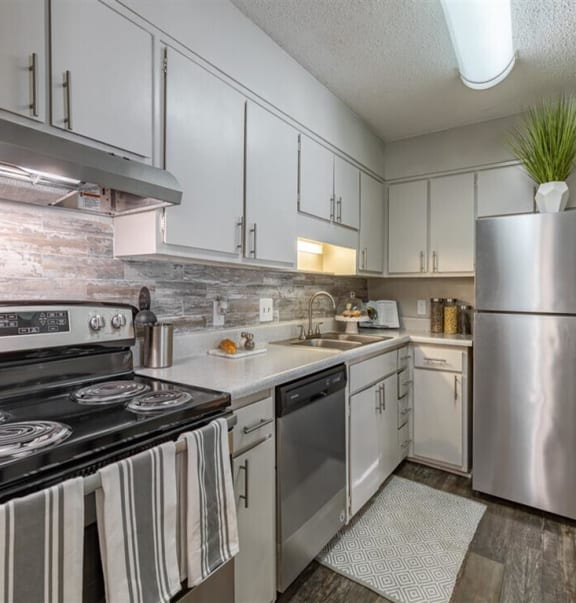 a kitchen with stainless steel appliances and white cabinets at Tucker Square, Stone Mountain, 30083