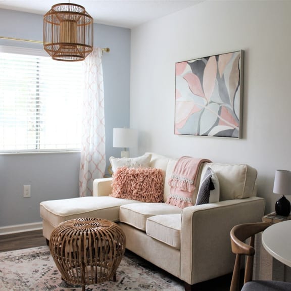 a living room with a couch and a chair and a window at Capital Flats & Magnolia Square Apartments, Raleigh, NC