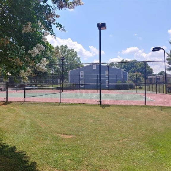a tennis court with a building in the background