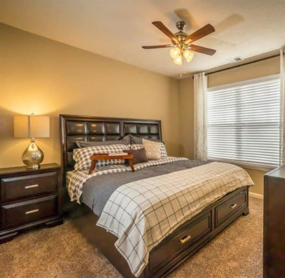 a bedroom with a bed and a ceiling fan