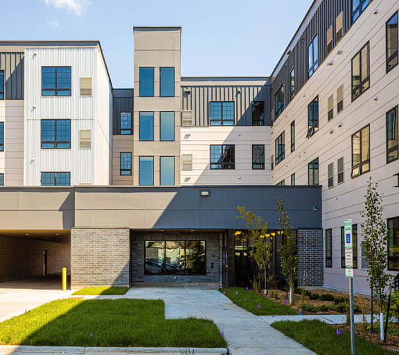 the entrance to a building with a sidewalk and grass at The Landing at 1001 NP, Fargo, North Dakota 58102
