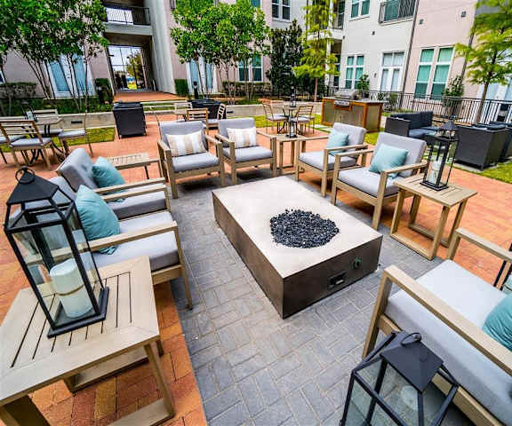 The courtyard with a table, chairs, and fire pits at Parkside at Firewheel Apartments. 