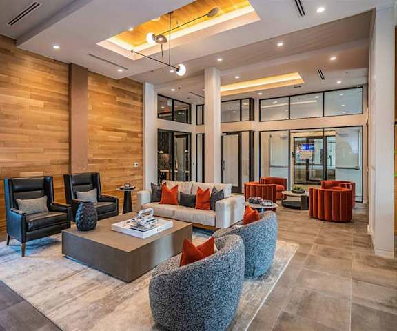 The resident lounge with a couches, decorations, plush chairs, and coffee tables at Magnolia on the Green Apartments. 