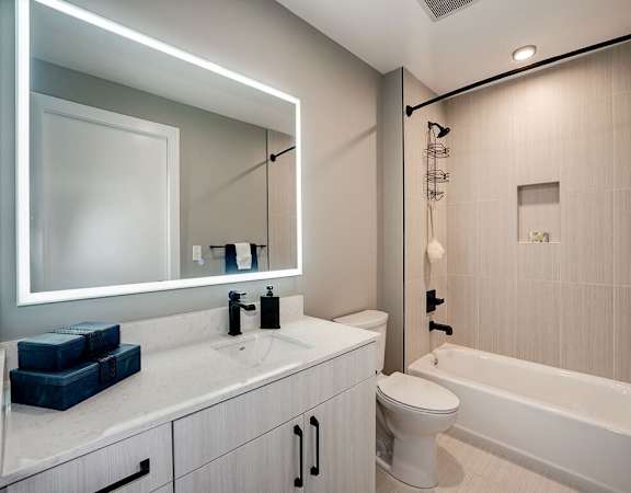 A modern bathroom with a white sink and a white toilet at Coda on H Apartments, Washington