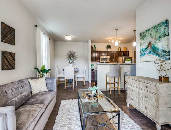 A modern living room with a grey sofa and a glass coffee table.