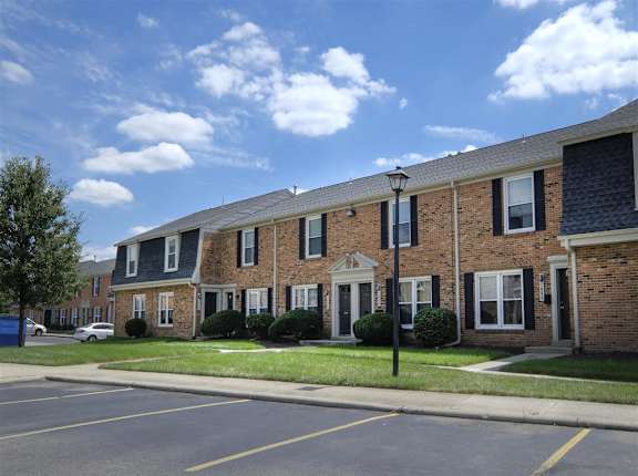 a row of brick apartment buildings on the side of a street