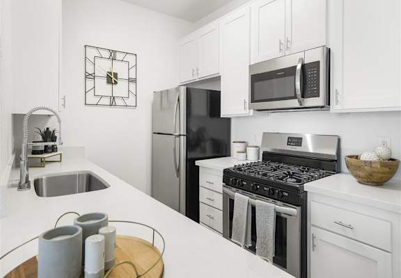 a kitchen with a stove top oven next to a sink at Enclave, California