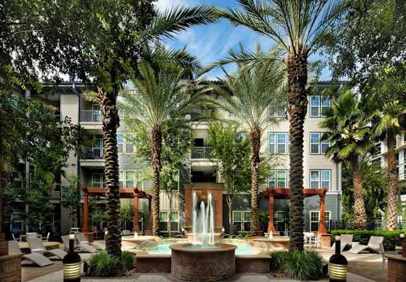 a fountain in the middle of a courtyard with palm trees