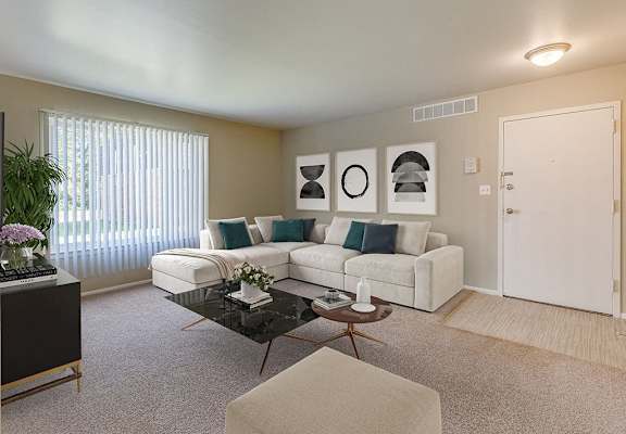 A living room with a white couch, a coffee table, and a potted plant.