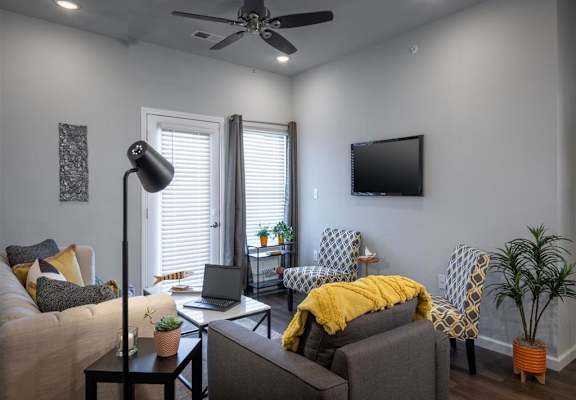 a living room with a couch and a ceiling fan