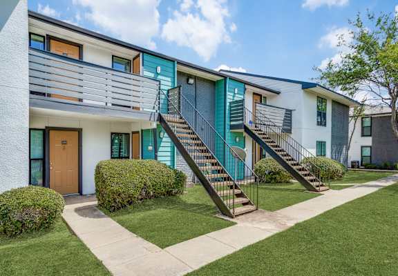 A modern apartment building with a green staircase.