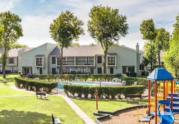 a playground with a pool in front of an apartment building