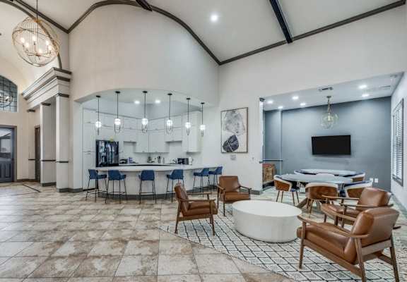 a large lobby with tables and chairs and a tv  at Valor at Harlingen, Harlingen, Texas