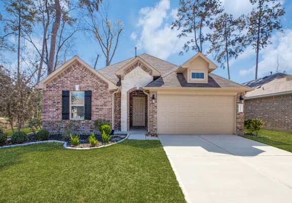 a house with a lawn and trees in the background