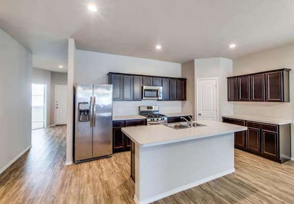 a large kitchen with a large island and stainless steel appliances