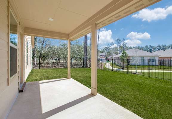 a covered patio with a view of a grassy yard