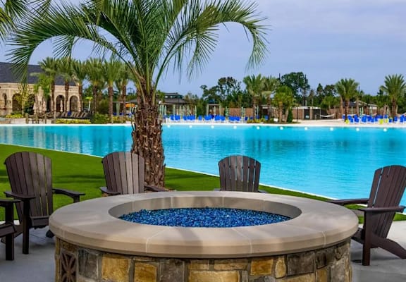 A pool area with a hot tub and chairs.