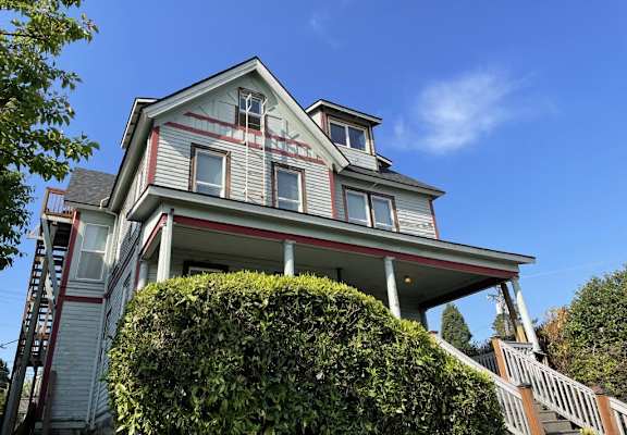 A house with a grey facade and a red staircase.