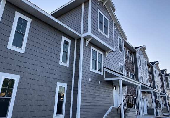 a row of houses with gray siding and white trim