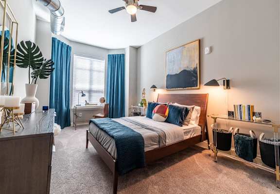 a bedroom with a bed and a ceiling fan at The Foundry Apartments , South Bend, IN