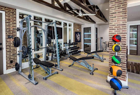 A home gym with a variety of equipment including a squat rack, bench, and weights.