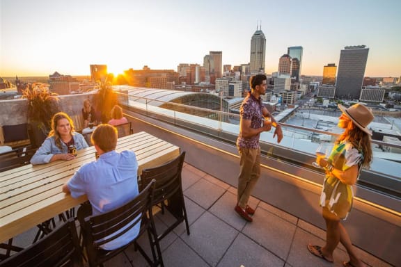 a group of people sitting at tables on top of a building at CityWay Apartments, Indianapolis