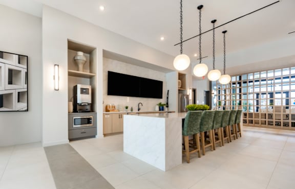 A modern kitchen with a white island and green chairs.