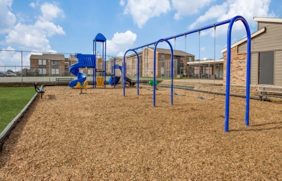 a playground with a blue slide and monkey bars