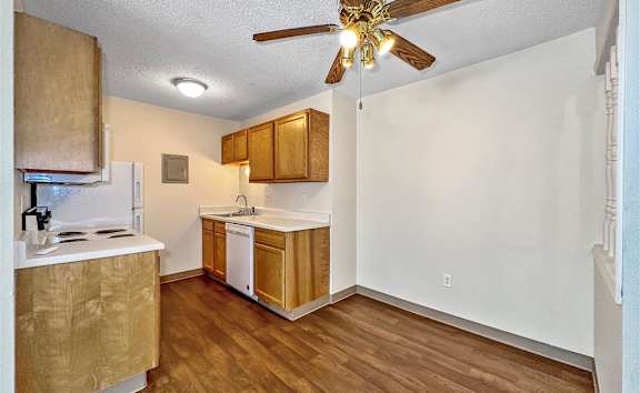 a kitchen with wood floors and a ceiling fan at Foxwood Apartments, Indianola