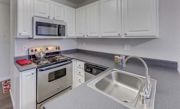 a kitchen with white cabinets and stainless steel appliances
