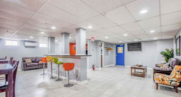 A spacious living room with a kitchen area in the background.