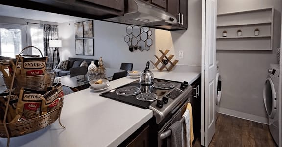 A kitchen with a stove top oven and a washing machine.