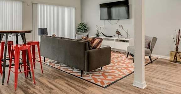 a living room with a couch and chairs and a tv at Aspen Landing, Kansas City, MO