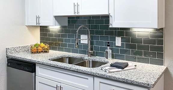 A kitchen with white cabinets and a granite countertop. at Latitude at Riverchase, Hoover, AL, 35216
