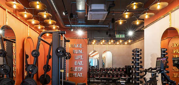 a gym with a lot of exercise equipment and lights on the ceiling