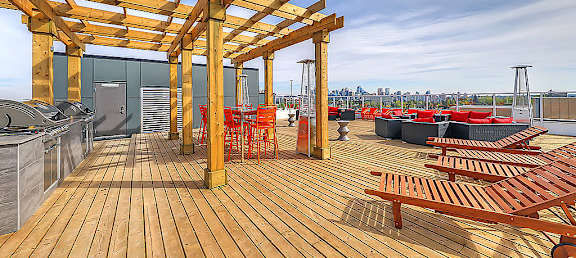 A wooden deck with red chairs and tables.