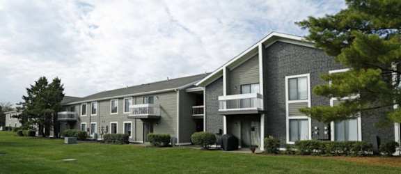 a building with two balconies and a grassy area in front of it