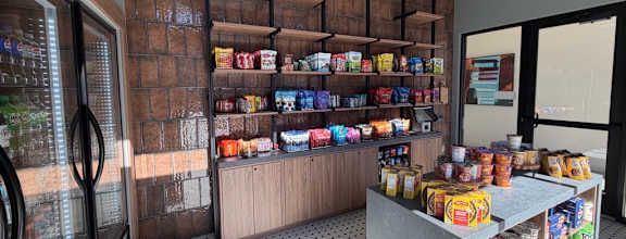 A store interior with a variety of products on shelves and a counter.
