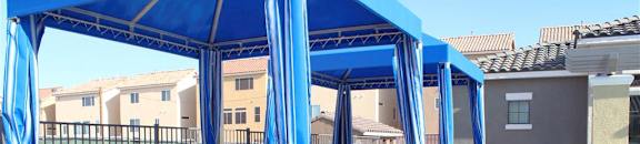 Poolside cabanas with lounge chairs on a sunny day at CHANDLER APARTMENT HOMES, Las Vegas