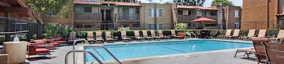 Community pool and hot tube with deck chairs and umbrellas on beautiful day at CASA GRANDE APARTMENT HOMES, Cypress, 90630