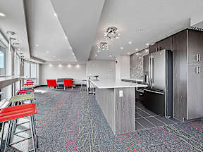 A modern kitchen with a bar area and seating.