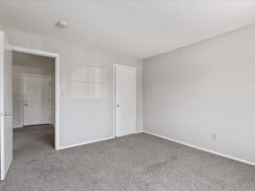 bedroom with white walls and a door to a closet