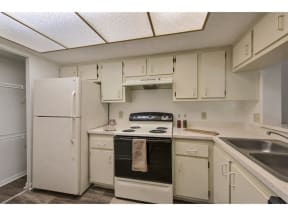 Kitchen with cabinets, pantry, sink, white refrigerator and oven