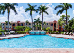 Outdoor pool with fountains surrounded by lounge chairs