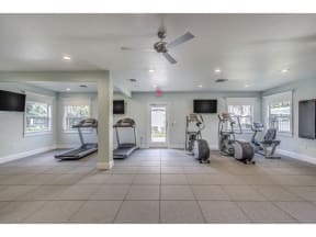 Fitness center with three tv's and cardio machines