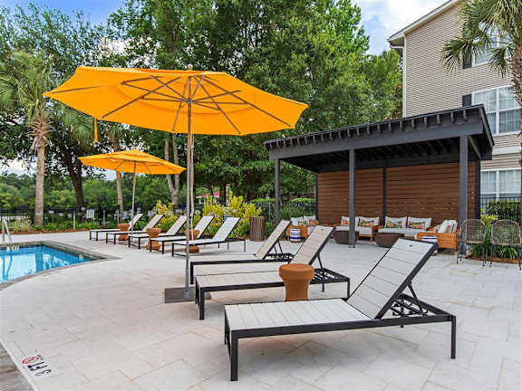 A poolside area with sun loungers and umbrellas.