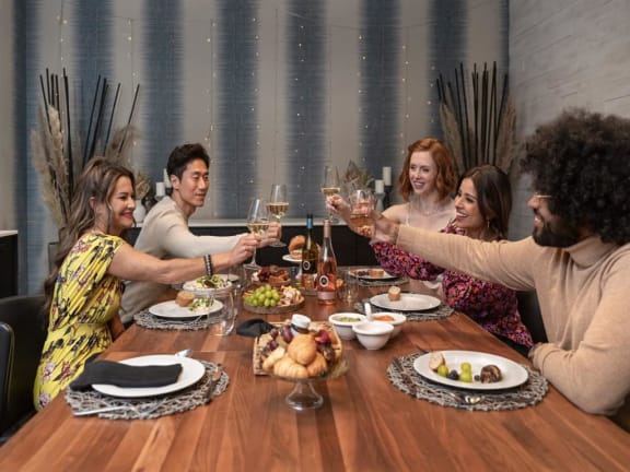 a group of people sitting around a table drinking wine