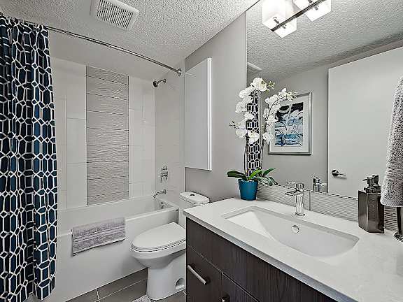 A bathroom with a white sink and a white toilet.