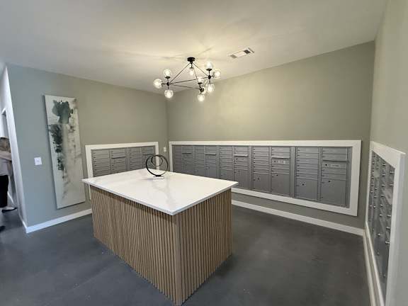 A room with a bed, a chandelier, and a wall of lockers.